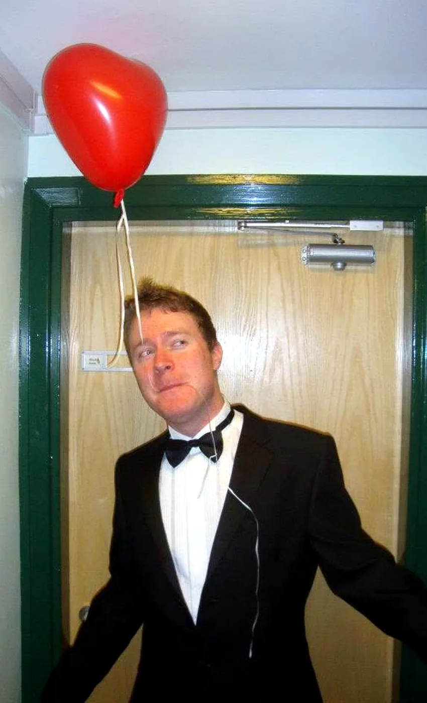 James in a bow tie with a red heart balloon