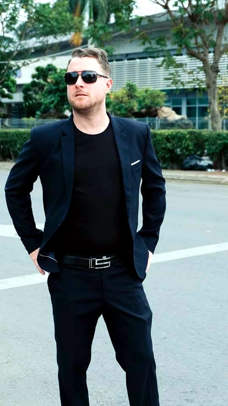 James in a dark suit and sunglasses